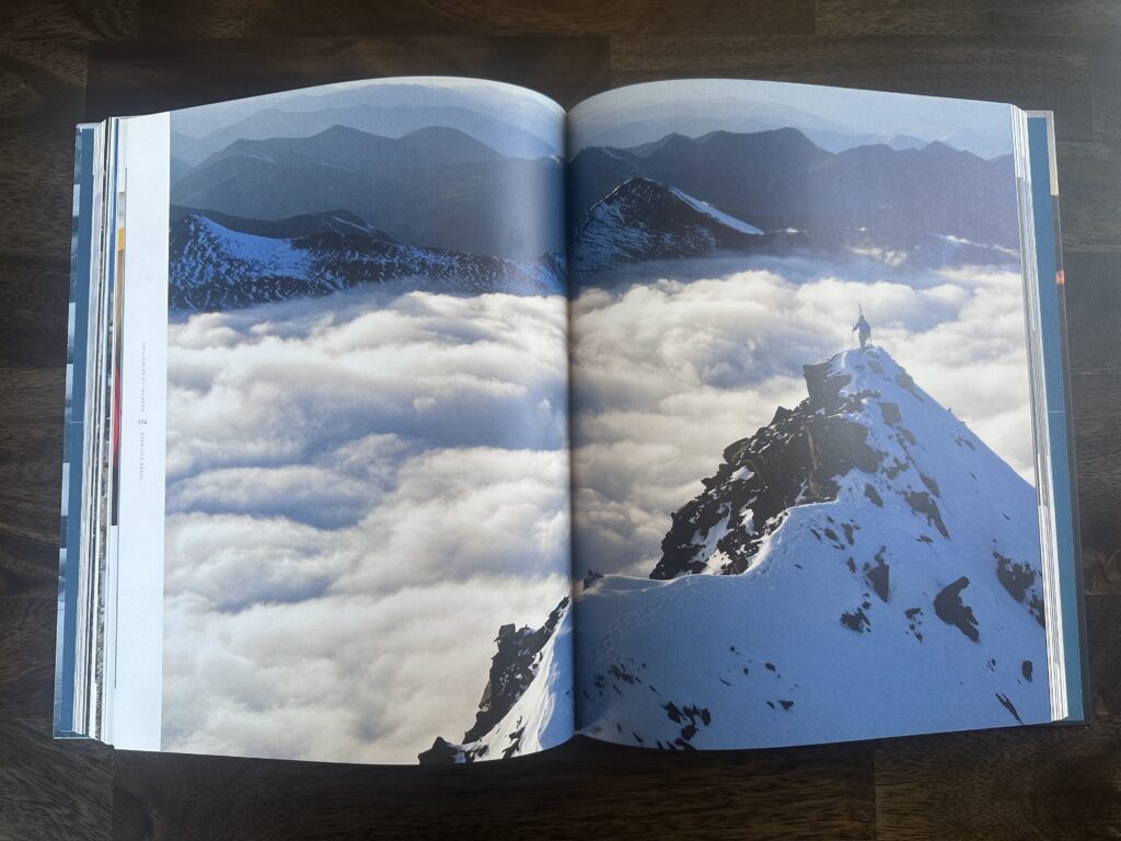 photo of a two page spread in the book depicting a skier on the top of a mountain